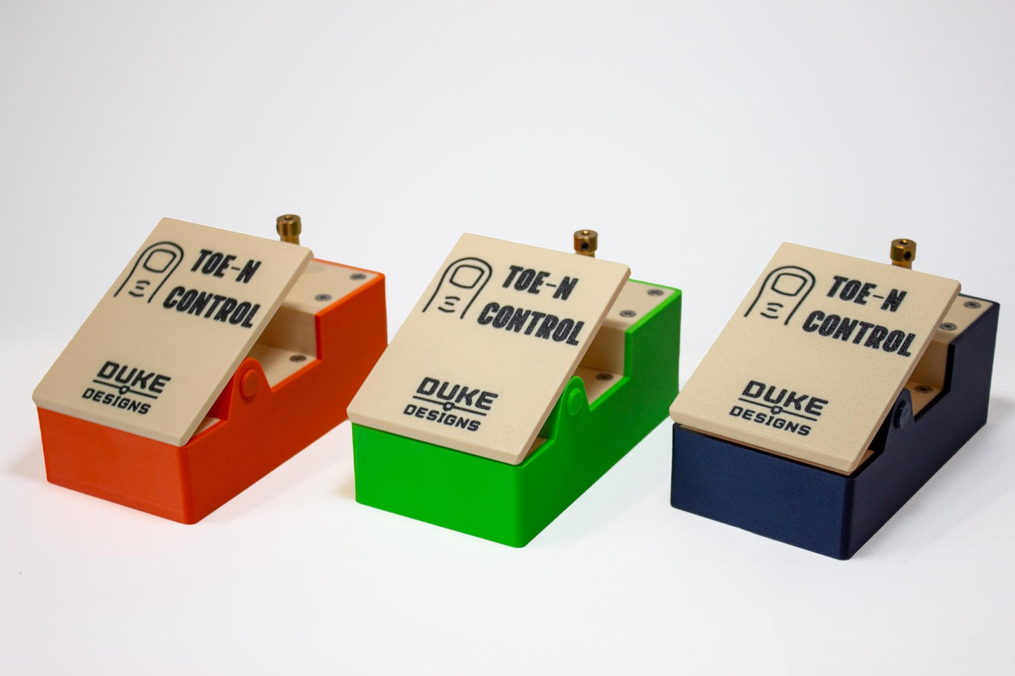 Three guitar pedals individually colored orange, green and blue